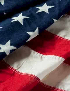 A close-up of an American flag showing blue with white stars and red-and-white stripes.